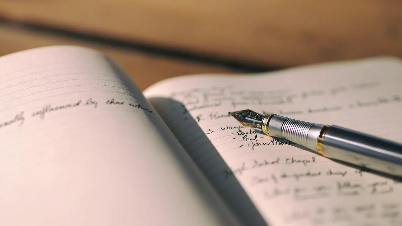 Un stylo plume posé sur un carnet couvert de notes manuscrites